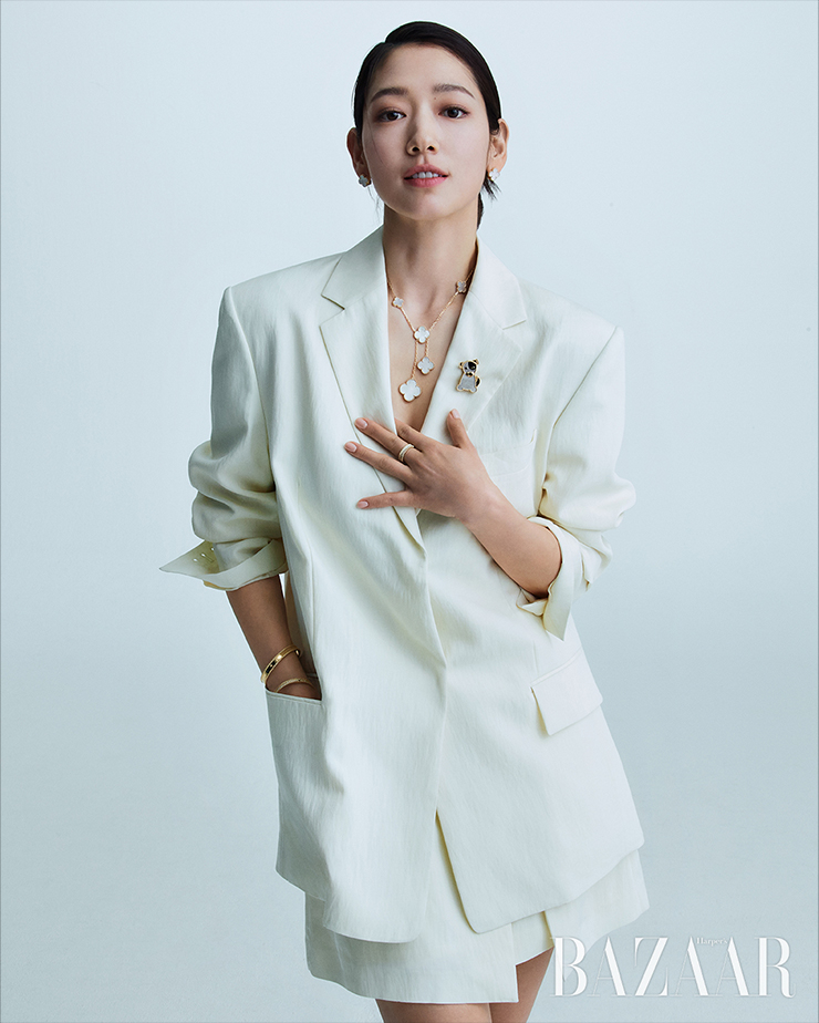 화이트 머더오브펄 ‘빈티지 알함브라’ 이어링, 각기 다른 사이즈의 화이트 머더오브펄 알함브라 모티프가 돋보이는 ‘매직 알함브라’ 네크리스, 화이트 머더오브펄과 오닉스로 이루어진 강아지 모티프의 ‘럭키 애니멀 시앙’ 클립, 골드 비즈 사이에 다이아몬드가 세팅된 ‘뻬를리 다이아몬드’ 링, 18K 옐로 골드의 ‘뻬를리 시그너처’ 브레이슬릿, 18K 옐로 골드에 다이아몬드가 파베 세팅된 ‘뻬를리 다이아몬드’ 브레이슬릿은 모두 Van Cleef & Arpels. 재킷, 스커트는 모두 Juun.J.