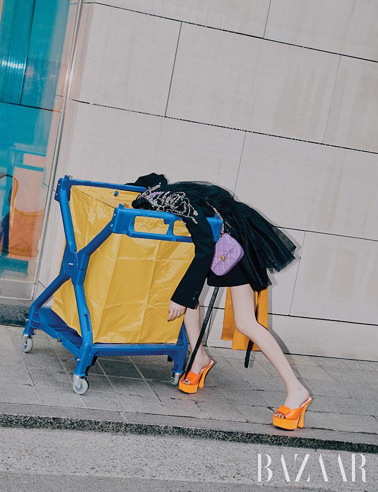 엠브로이더리 재킷은 Alexander McQueen. 언밸런스 스커트는 3백77만원 Prada. 퀼팅 백은 Chanel. 샌들은 Roger Vivier.