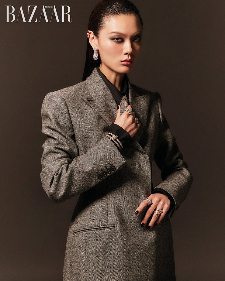 세 개의 T 장식이 특징인 ‘T1’ 이어커프, 오른손 약지에 착용한 화이트 골드 소재의 ‘T1 와이드 풀 다이아몬드’ 반지, ‘T1 와이드 풀 다이아몬드 힌지드’ 뱅글, 로즈 골드 소재의 ‘T1 와이드 풀 다이아몬드 힌지드’ 뱅글, 왼손 약지에 레이어드한 ‘T1 와이드 풀 다이아몬드’ 반지, 옐로 골드 소재의 ‘T1 와이드 풀 다이아몬드’ 반지는 모두 Tiffany & Co.. ‘플륌 드 펑’ 귀고리는 5천만원대, 목걸이로 연출 가능한 ‘쎄뻥 보헴’ 브로치는 2천만원대 Boucheron. 오른손 검지에 착용한 ‘토르사드 드 쇼메’ 반지는 3천4백만원대 Chaumet. 왼손 검지에 착용한 ‘임페리얼’ 컬렉션 반지는 3천6백만원대 Chopard. 재킷, 셔츠, 타이는 모두 Sportmax.