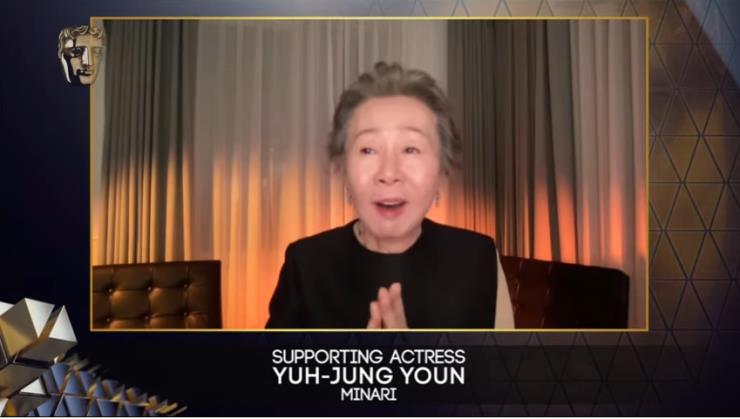 이름이 언급되자 기뻐하고 있는 윤여정. 이어링은 까르띠에 플뤼 드 까르띠에 (Pluie de Cartier), 의상은 디올 비대칭 드레스.