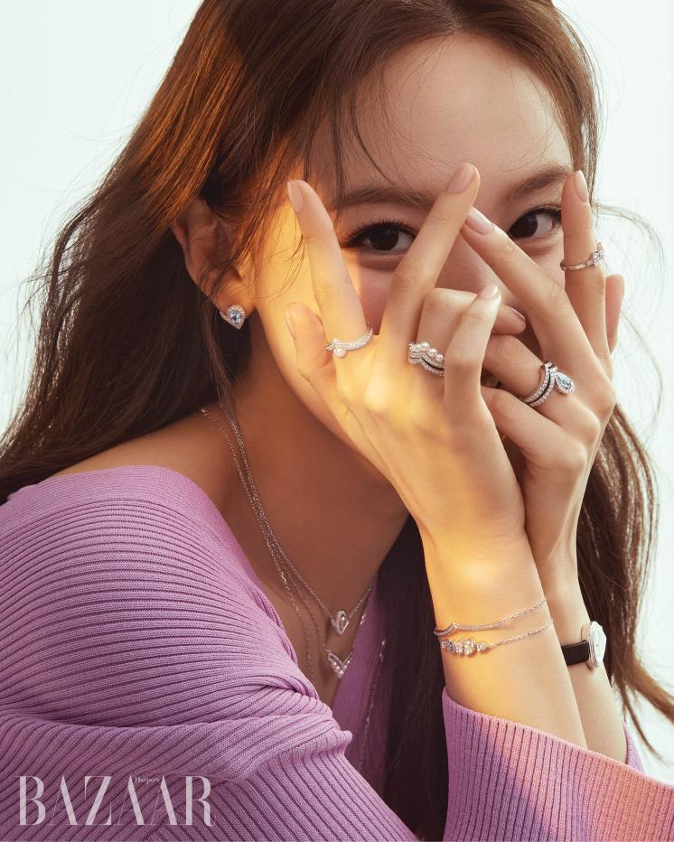 화이트 골드에 아쿠아마린과 다이아몬드를 파베 세팅한 ‘조세핀 아그레뜨 이어링’, 오른손 검지와 약지에 낀 반지는 모두 ‘조세핀 아그레뜨 링’, 왼손 약지에 레이어드한 화이트 골드에 0.6캐럿 아쿠아마린과 파베 다이아몬드가 세팅된 ‘조세핀 아그레뜨 링’, 함께 착용한 ‘조세핀 아그레뜨 링’, 왼손 검지에 낀 ‘조세핀 롱드 다그레뜨 링’, 다이아몬드 세팅의 화이트 골드 소재에 인그레이빙 다이얼을 더한 ‘조세핀 아그레뜨 워치’, 오른쪽 손목 위의 ‘조세핀 아그레뜨 브레이슬릿’, 아쿠아마린과 파베 다이아몬드가 세팅된 ‘조세핀 롱드 다그레뜨 브레이슬릿’, 레이어드한 목걸이는 위부터 ‘조세핀 아그레뜨 네크리스’, ‘조세핀 아그레뜨 펄 네크리스’, ‘조세핀 아그레뜨 네크리스’ 모두 Chaumet. 브이넥 니트는 Eudon Choi.