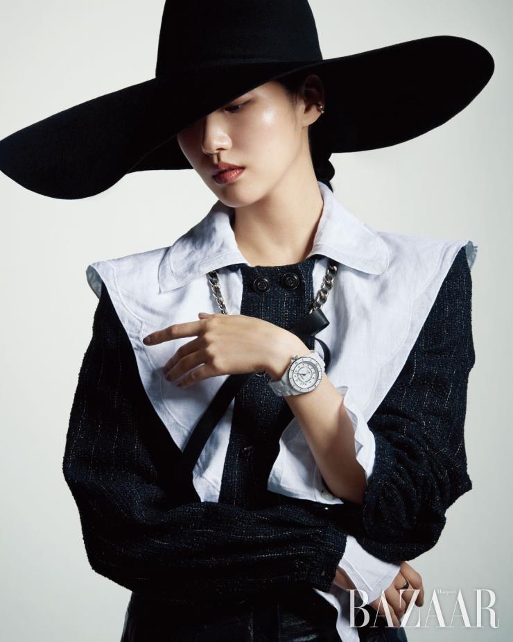 퀼팅 디테일의 ‘코코 크러쉬’ 이어커프, 다이아몬드 인디케이터가 장식된 세라믹 소재의 ‘J12 화이트’ 워치, 오른손 중지에 낀 베이지 골드 ‘코코 크러쉬’ 스몰 링은 모두 Chanel Watch & Fine Jewelry. 모자는 Shinjeo.