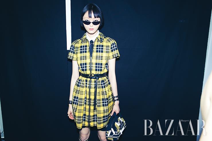 유니크한 마스크를 가진 소유정이 ‘체크앤디올’ 패턴의 미니 드레스를 입고 있다.
