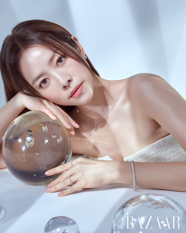 다이아몬드 장식의 18K 화이트 골드 소재 듀얼샤인 (라운드) 귀고리 56만원, 듀얼샤인 (라운드) 목걸이 65만원, 다이아몬드 장식의 18K 화이트 골드 소재 모닝듀 0.07캐럿 테니스 팔찌 1천1백99만원, 검지에 착용한 18K 핑크 골드와 플래티넘 소재의 투오브하트V 0.03캐럿 반지 2백79만원, 약지에 착용한 18K 화이트 골드 소재의 모닝듀크로스 0.06캐럿 반지 1백37만원 모두 Golden dew.