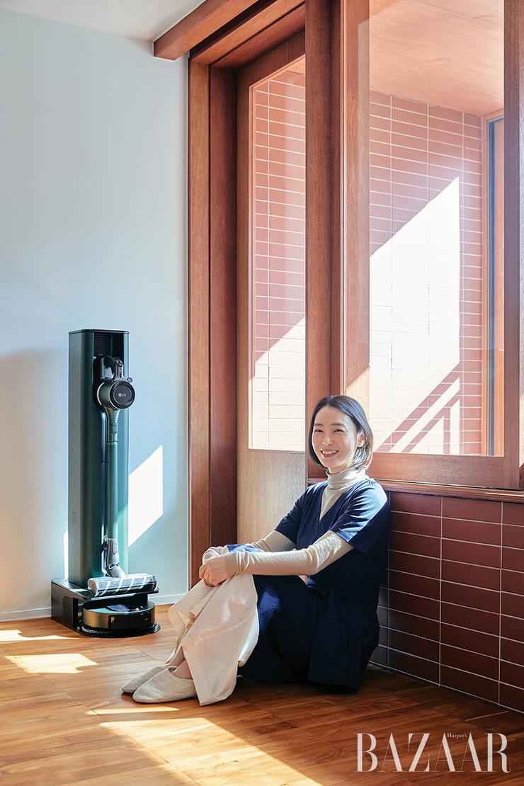 LG 코드제로 A9S 올인원타워와 M9 물걸레 로봇청소기와 올인원타워 M9 결합 키트. 네이비 컬러 점프수트는 Weekend MaxMara. 안에 입은 터틀넥 톱은 Cos. 