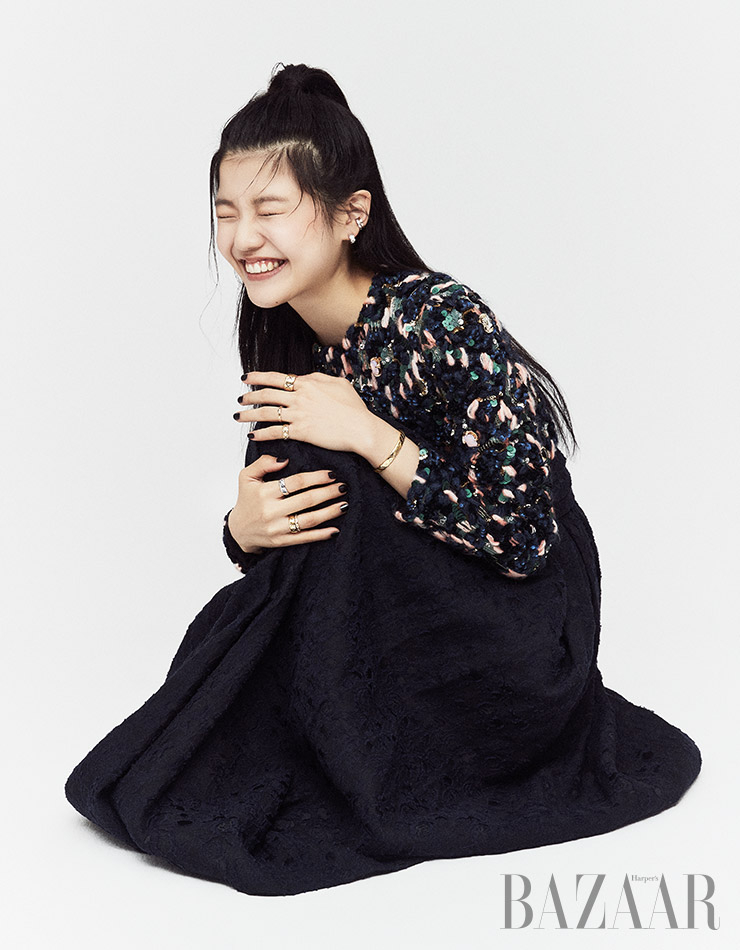 퀼팅 모티프의 이어커프 2개, 화이트 골드에 다이아몬드가 장식된 귀고리, 왼손 검지에 착용한 옐로 골드 반지, 약지에 착용한 베이지 골드 반지, 소지에 착용한 베이지 골드에 다이아몬드가 장식된 반지, 옐로 골드 팔찌, 오른손 검지에 착용한 화이트 골드 반지, 약지에 레이어드한 옐로 골드 반지 2개는 모두 ‘코코 크러쉬’ 컬렉션 Chanel Fine Jewelry. 드레스는 Chanel.