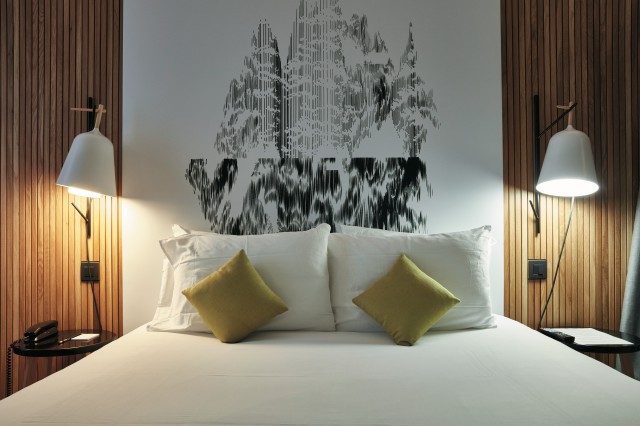 압델카데르 벤샤마의 작품이 침대의 헤드로 되어 있는 방.