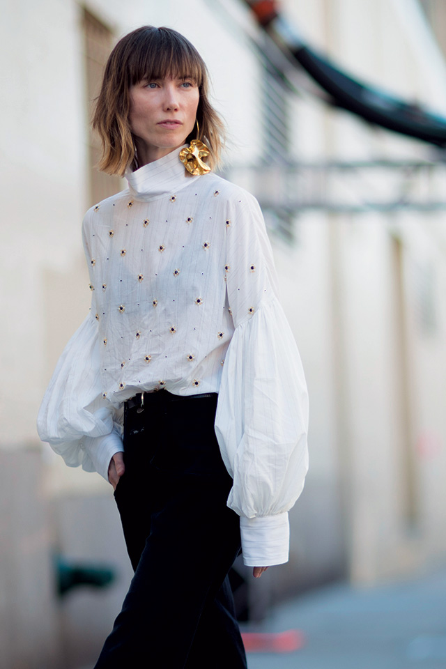 비숍 소매 블라우스에 오버사이즈 귀고리를 매치한 안야 지오우로바