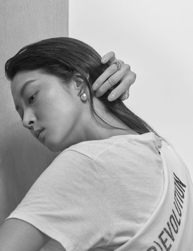 또 다른 티셔츠 위에 겹쳐서 연출한 ‘DIO(R)EVOLUTION’ 레터링의 티셔츠, 진주 귀고리, 별자리 모티프의 반지, 손가락 마디에 착용한 반지는 모두 Dior 제품.