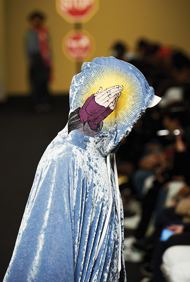 기도하는 손 모양의 그래픽 프린트가 돋보이는 벨벳 케이프