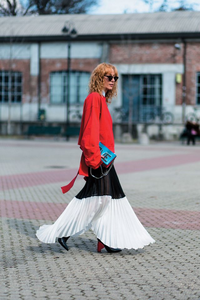 컷아웃 디테일의 베트멍 스웨트셔츠에 플리츠 스커트와 액세서리로드레시한 요소를 주입했다.