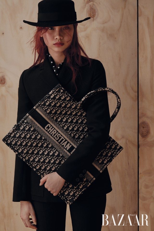 팬츠수트, 클래식한 중산모, 실크 스카프, 로고 플레이의 오버사이즈 백, 플랫 샌들은 모두 Dior 제품.