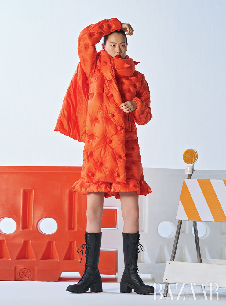 패딩 재킷, 쇼츠, 머플러는 모두 1 Moncler JW Anderson. 레이스업 부츠는 Moncler Collection.