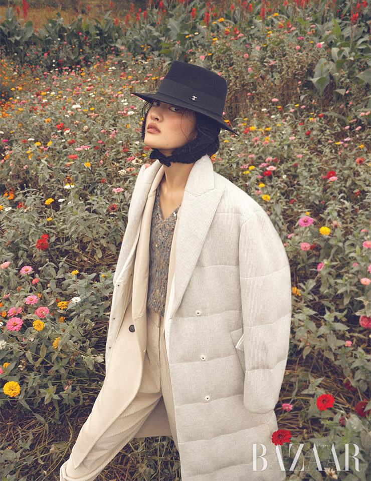 니트 베스트, 레이어드한 코트, 팬츠는 모두 Brunello Cucinelli. 페도라는 Chanel.