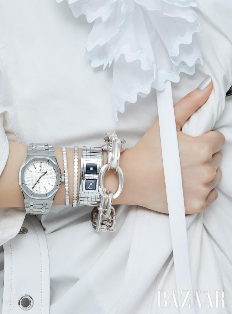 (왼쪽부터) 옥타곤 베젤이 인상적인 ‘로열 오크’ 시계는 Audemars Piguet. 화이트 골드 소재의 ‘콰트로 클루 드 파리 라이트’ 뱅글은 6백만원대 Boucheron. 벌집 모티프의 ‘비 마이 러브 컬렉션’ 뱅글은 6백만원대 Chaumet. ‘코드 코코’ 시계는 Chanel Watches. 체인 팔찌는 Hermès. 코트, 러플 깃 장식, 이너로 입은 가죽 드레스는 모두 Louis Vuitton.
