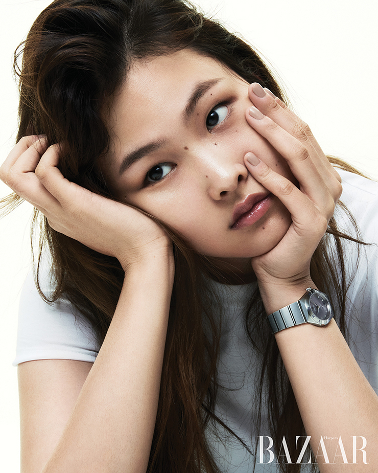 매혹적인 파촐리 블로섬 컬러 다이얼과 화이트 골드 소재의 ‘컨스텔레이션 쿼츠 28mm’ 워치는 Omega. 티셔츠는 Cos.