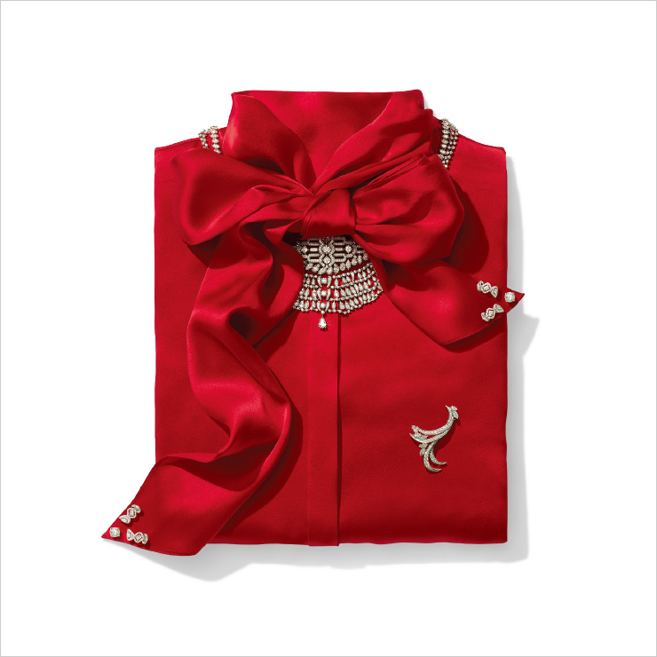 리본 매듭 아래에 놓인 기하학적 패턴 브로치는 Cartier Coloratura High Jewelry. 그 아래 한 줄로 이어진 다이아몬드 목걸이, 새 모티프 브로치는 Harry Winston. 3단으로 이루어진 목걸이는 Cartier High Jewelry. 리본 끝에 놓인 스터드는 De Beers. 그 위에 V자로 놓인 귀고리는 Messika Paris. 블라우스는 Oscar de la Renta.
