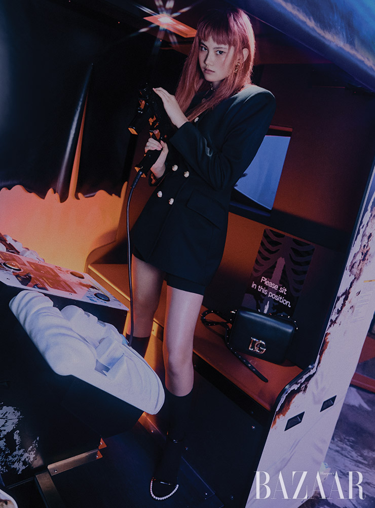 더블 버튼 재킷, 쇼츠, 귀고리, 초커, 카프 스킨 소재의 ‘3.5’ 백, 양말, 진주 장식 스트랩 힐은 모두 Dolce & Gabbana.