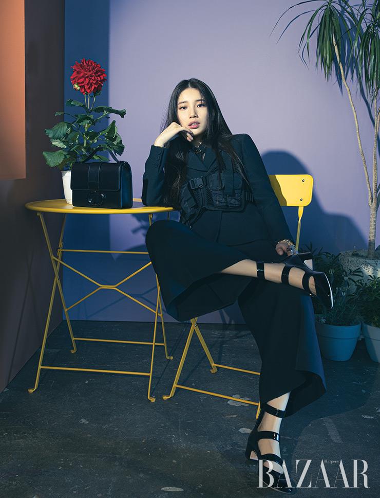 재킷, 포켓 베스트, 팬츠, 팔찌, 테이블에 놓은 ‘30 Montaigne’ 백, ‘D-Doll’ 펌프스는 모두 Dior.