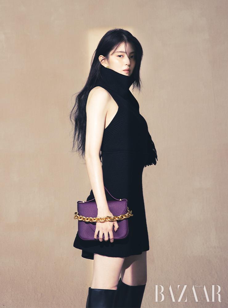 원 숄더 니트 톱, 스커트, 귀고리, 스몰 사이즈의 ‘마운트’ 백, 사이하이 부츠는 모두 Bottega Veneta.