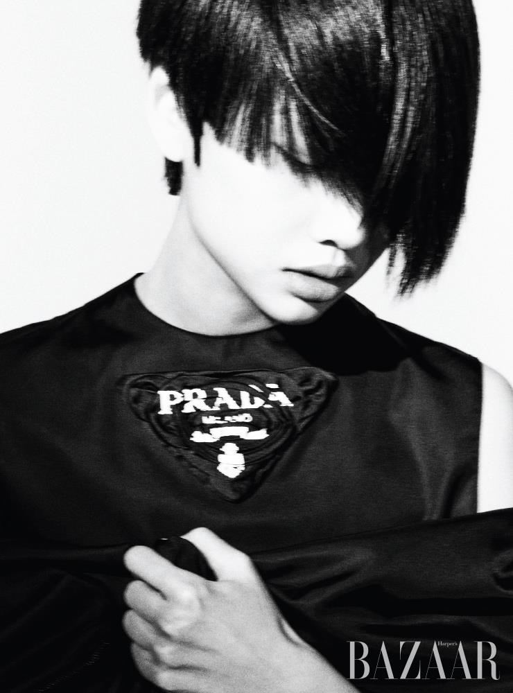 블랙 리-나일론 코트와 슬리브리스 톱은 모두 Prada.
